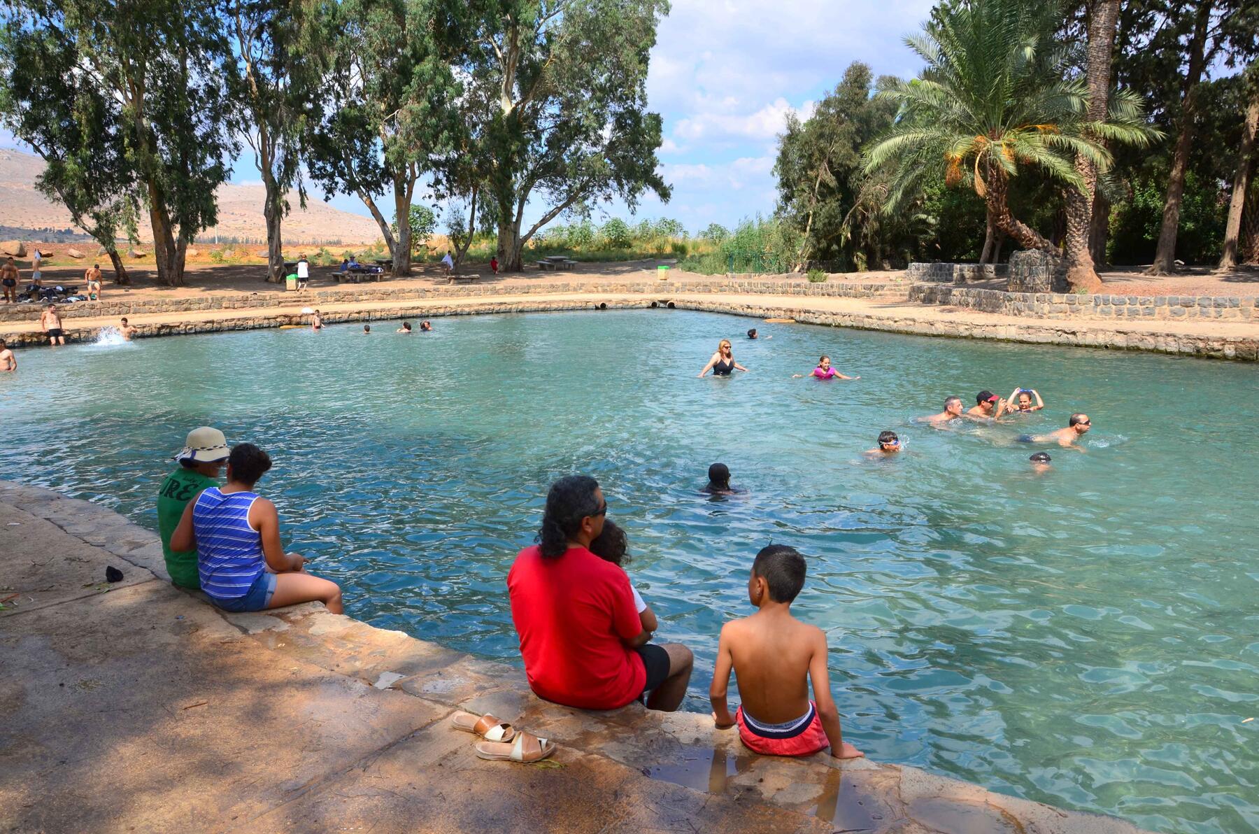 Natural-style pool with families swimming in Beit Sheâ€™an Valley, Israel